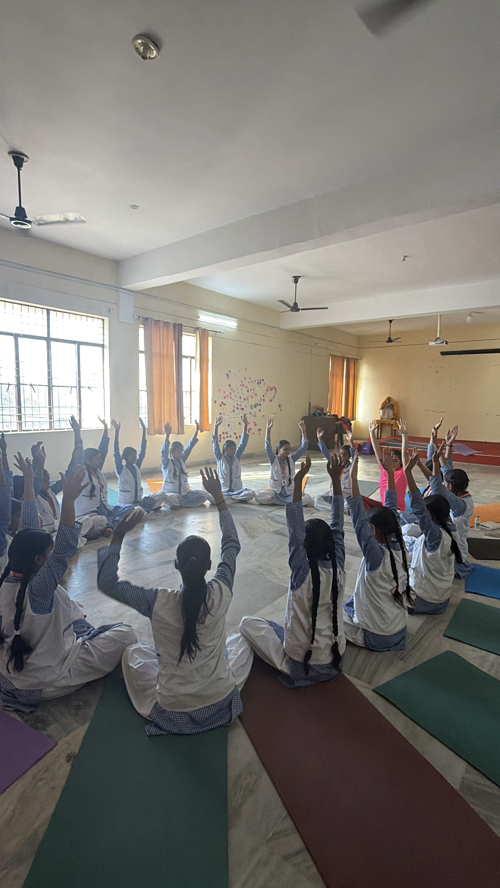 Yoga session winding down with students resting in savasana in Ferozabad, India